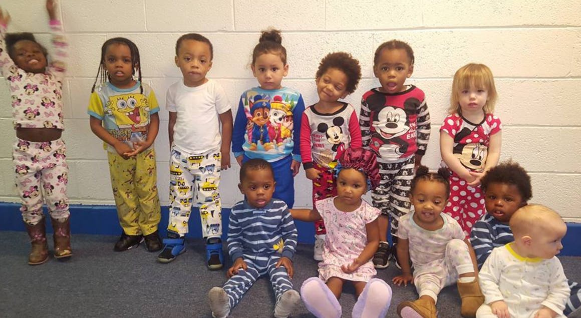 Group of children in pajamas standing and sitting