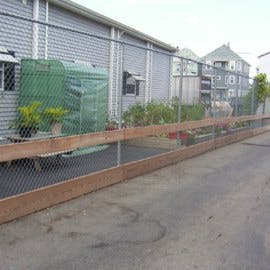 Chain link fence with a wooden top and bottom rail