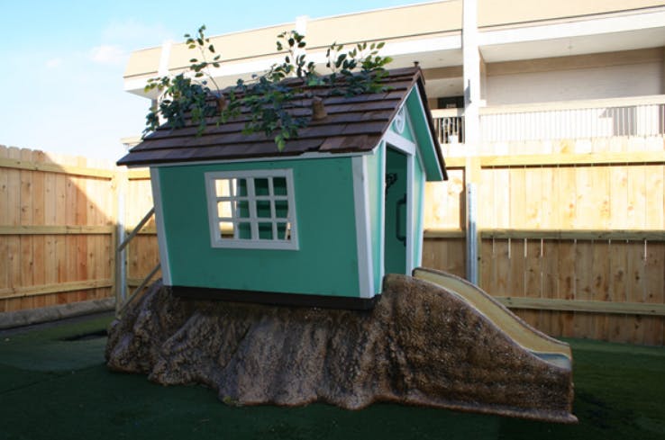 Playhouse on a tree stump with a slide