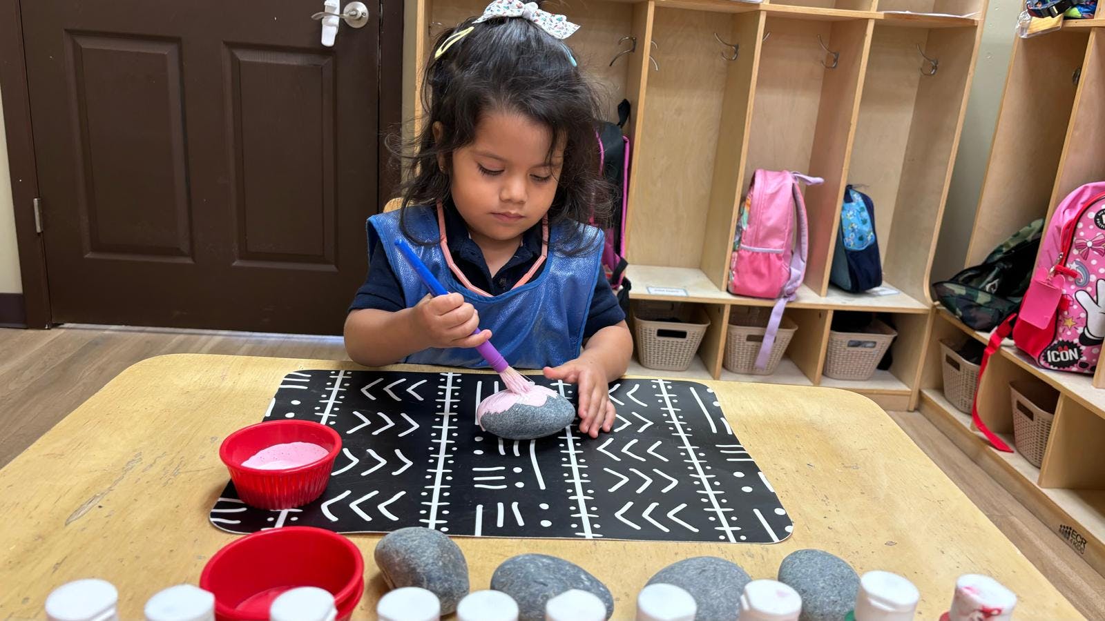 Child painting a rock with a brush