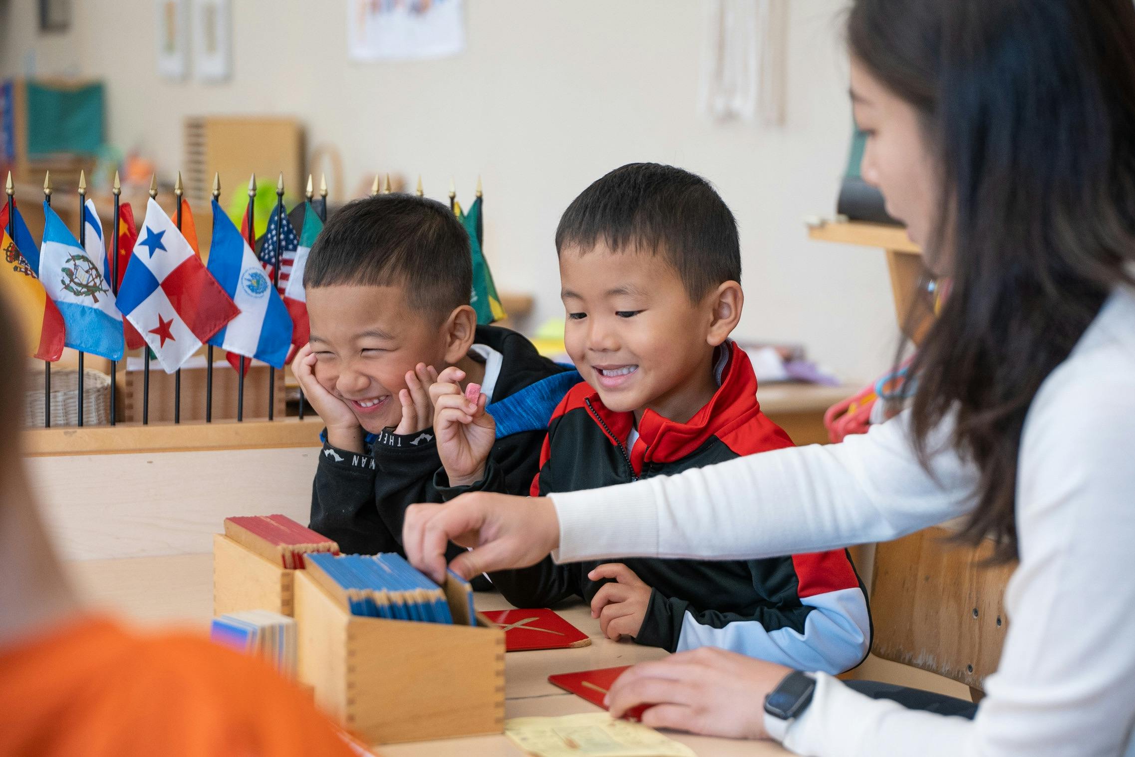 Adult and two children at a table with learning materials