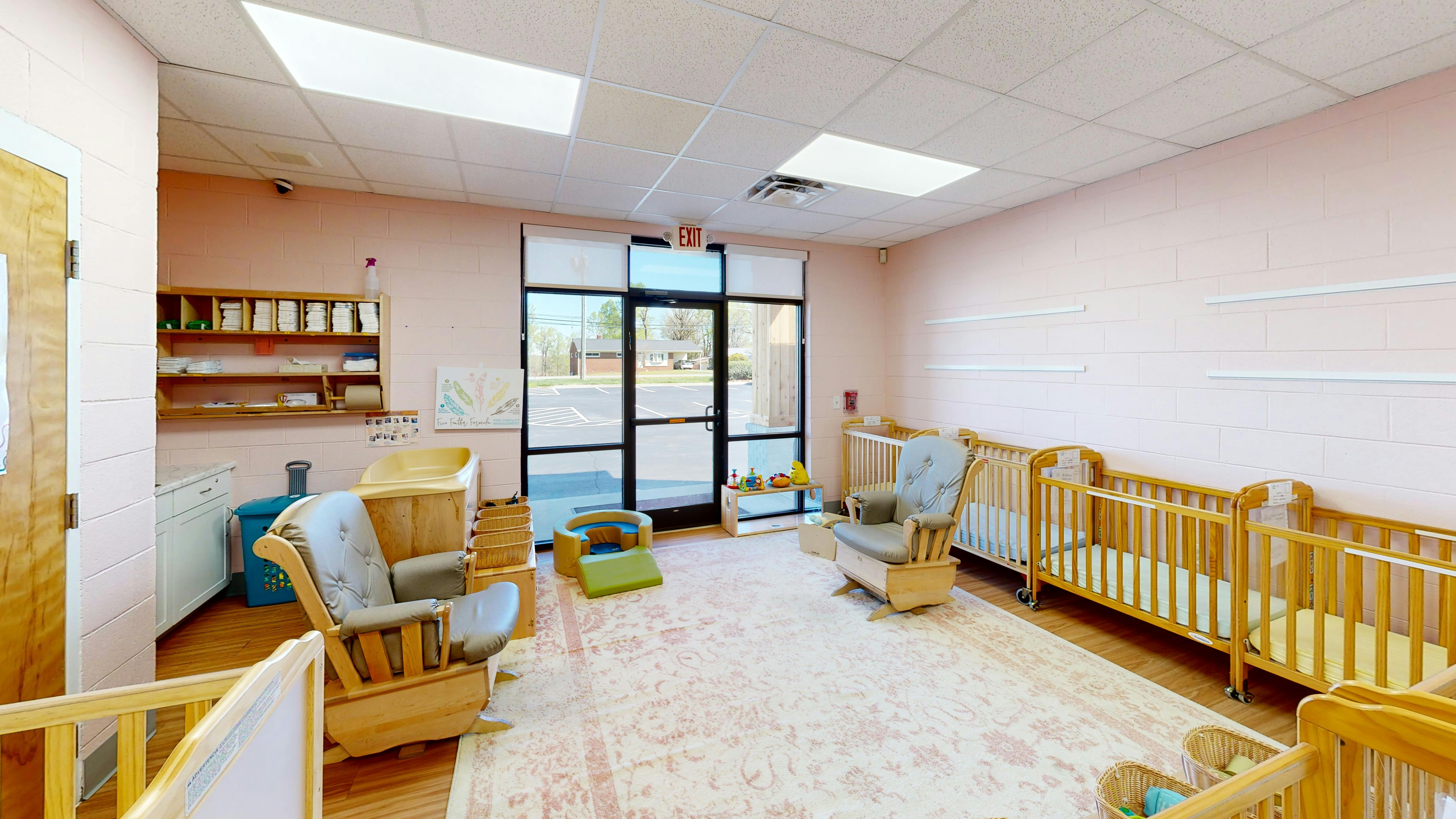 Nursery room with multiple cribs and a rocking chair
