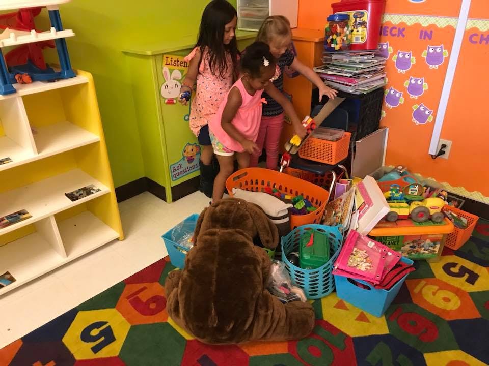 Three children playing with toys in a room