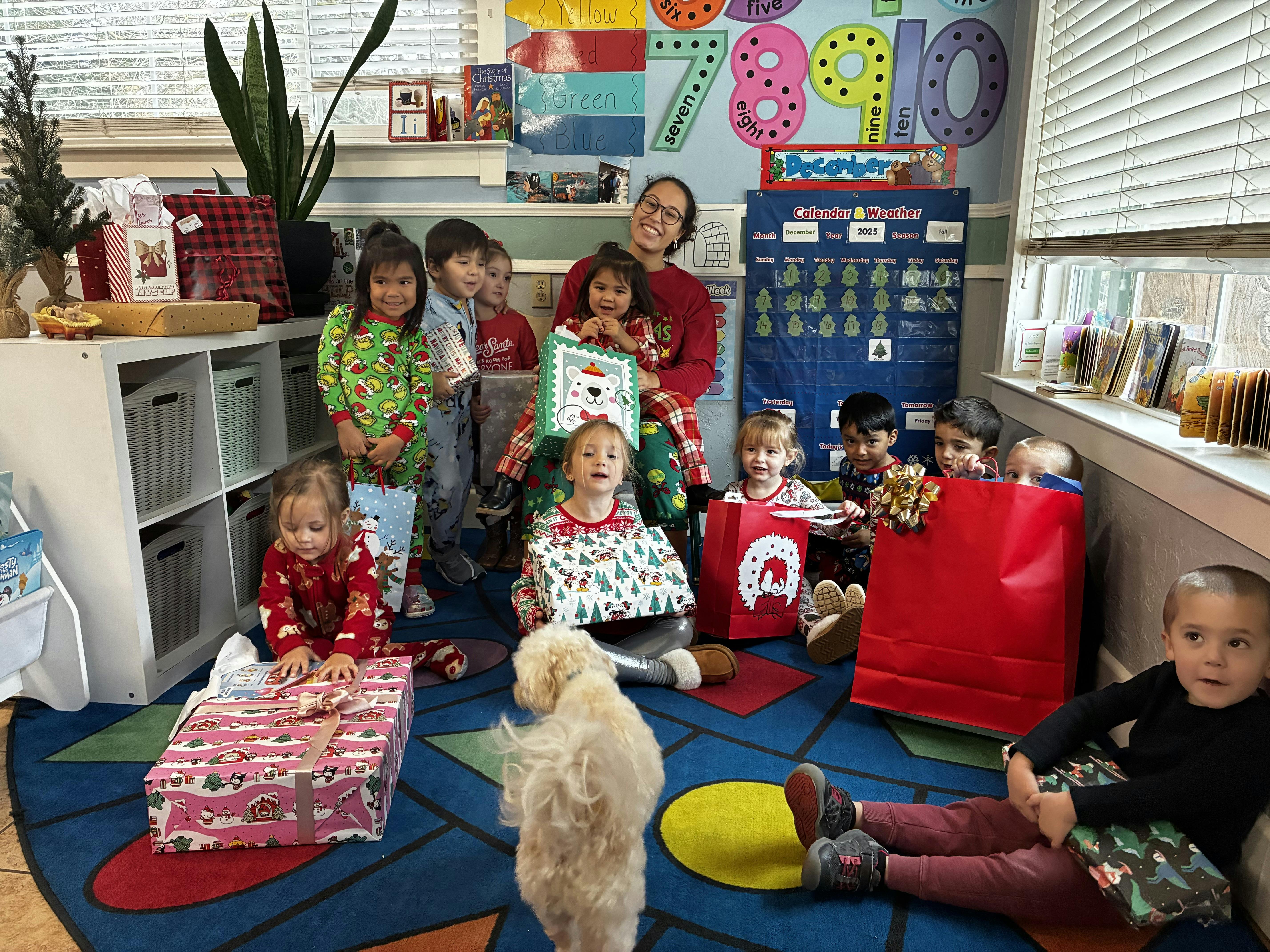 People and children gathered in a room with Christmas gifts