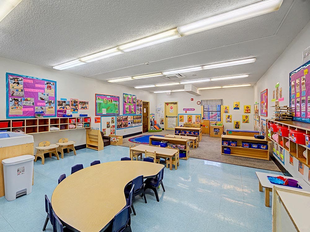 Empty colorful children's classroom with small tables and chairs