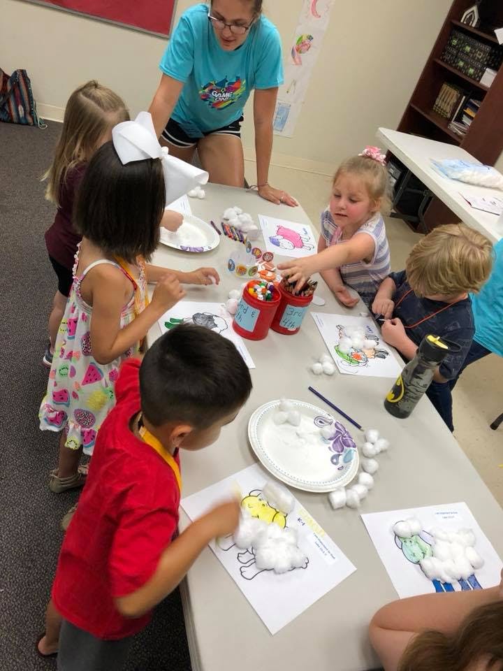 Adult and children doing crafts at a table