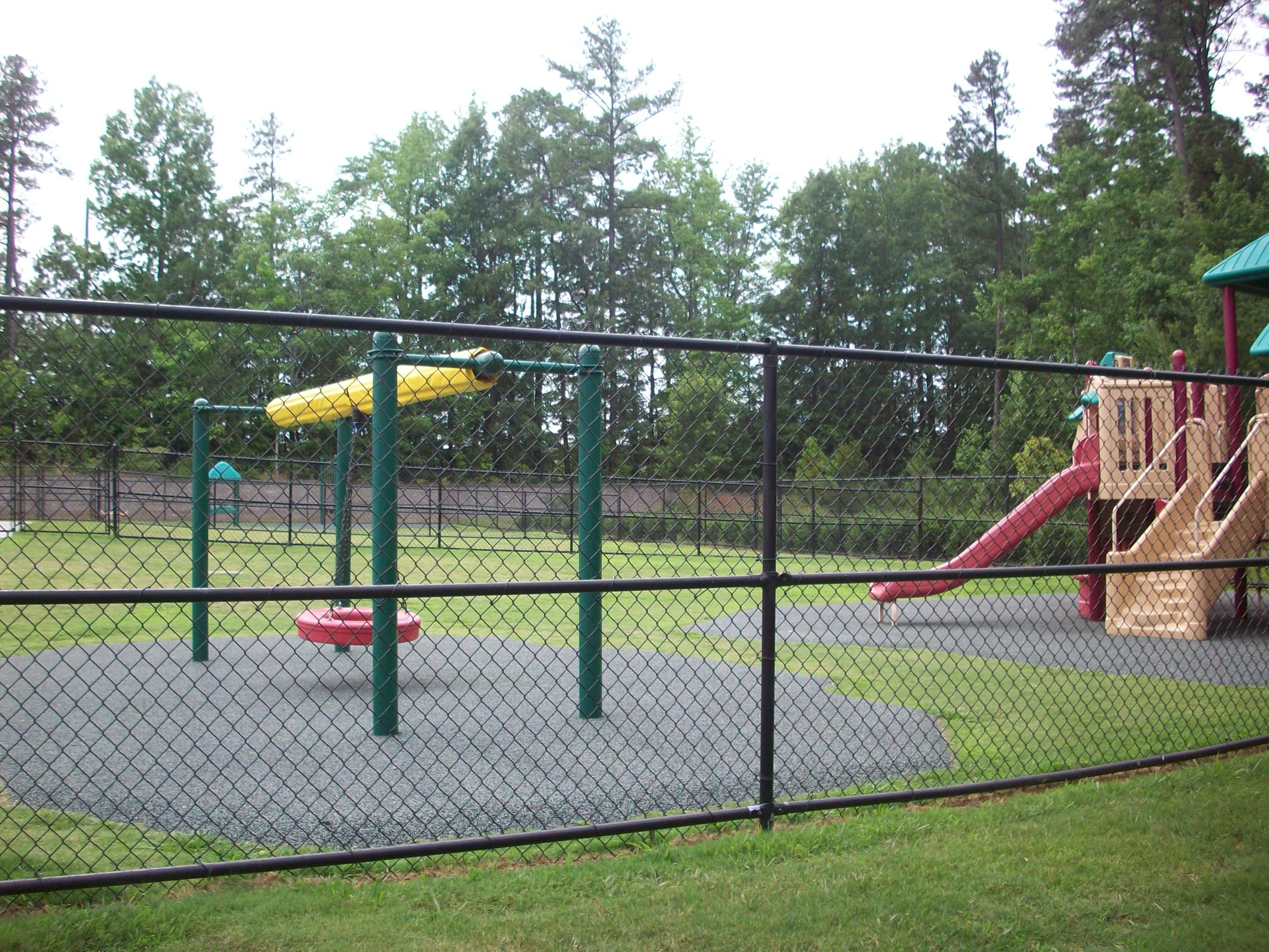 Playground with a chain link fence in the foreground