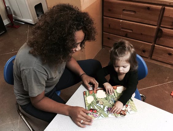 Person and child looking at a puzzle book