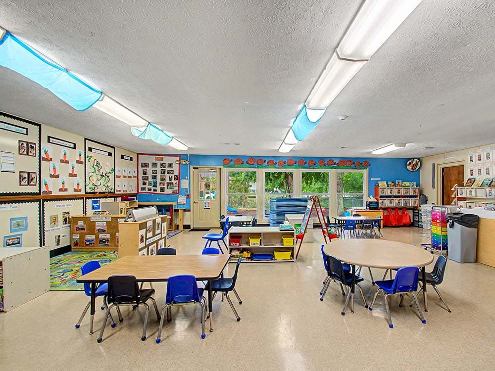 Empty colorful classroom with small tables and chairs