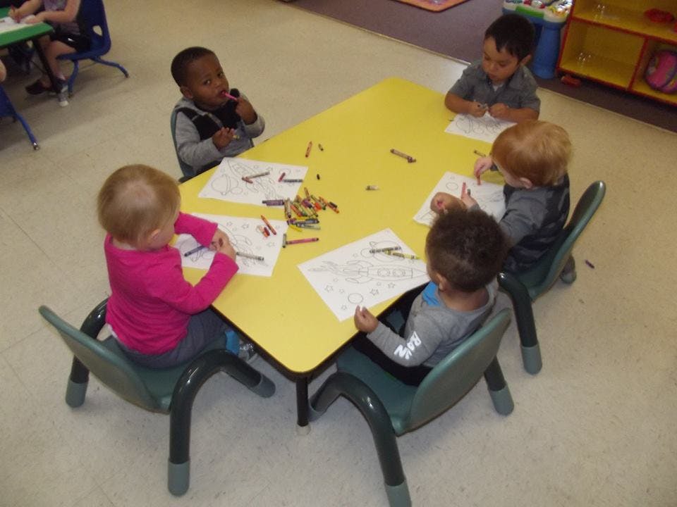 Children sitting at a table coloring