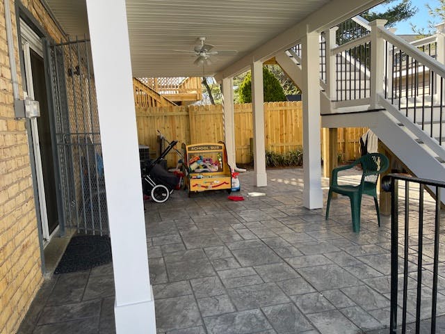 Covered patio with stamped concrete, a stroller, and a child's toy