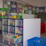 Storage unit with clear bins of toys in a classroom