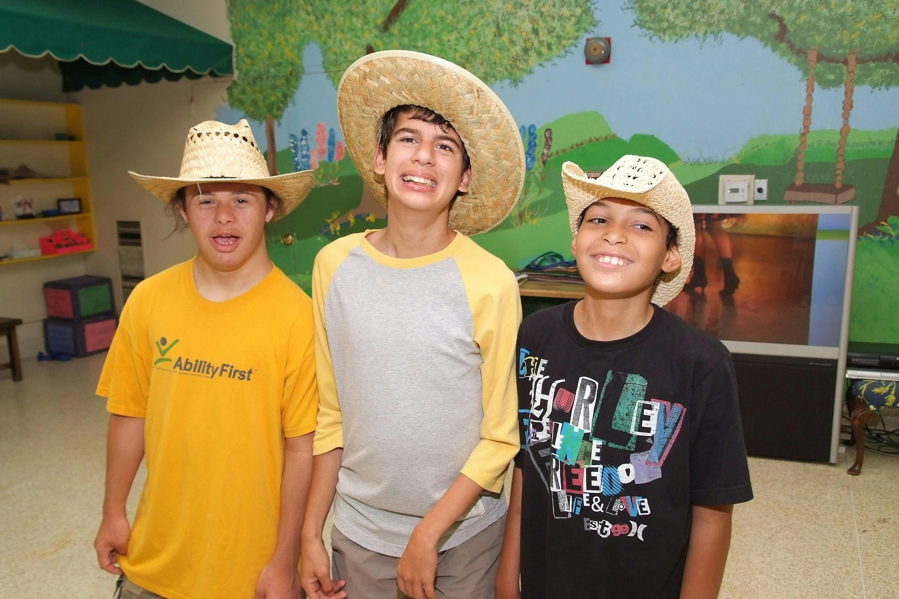 Three teens wearing straw hats