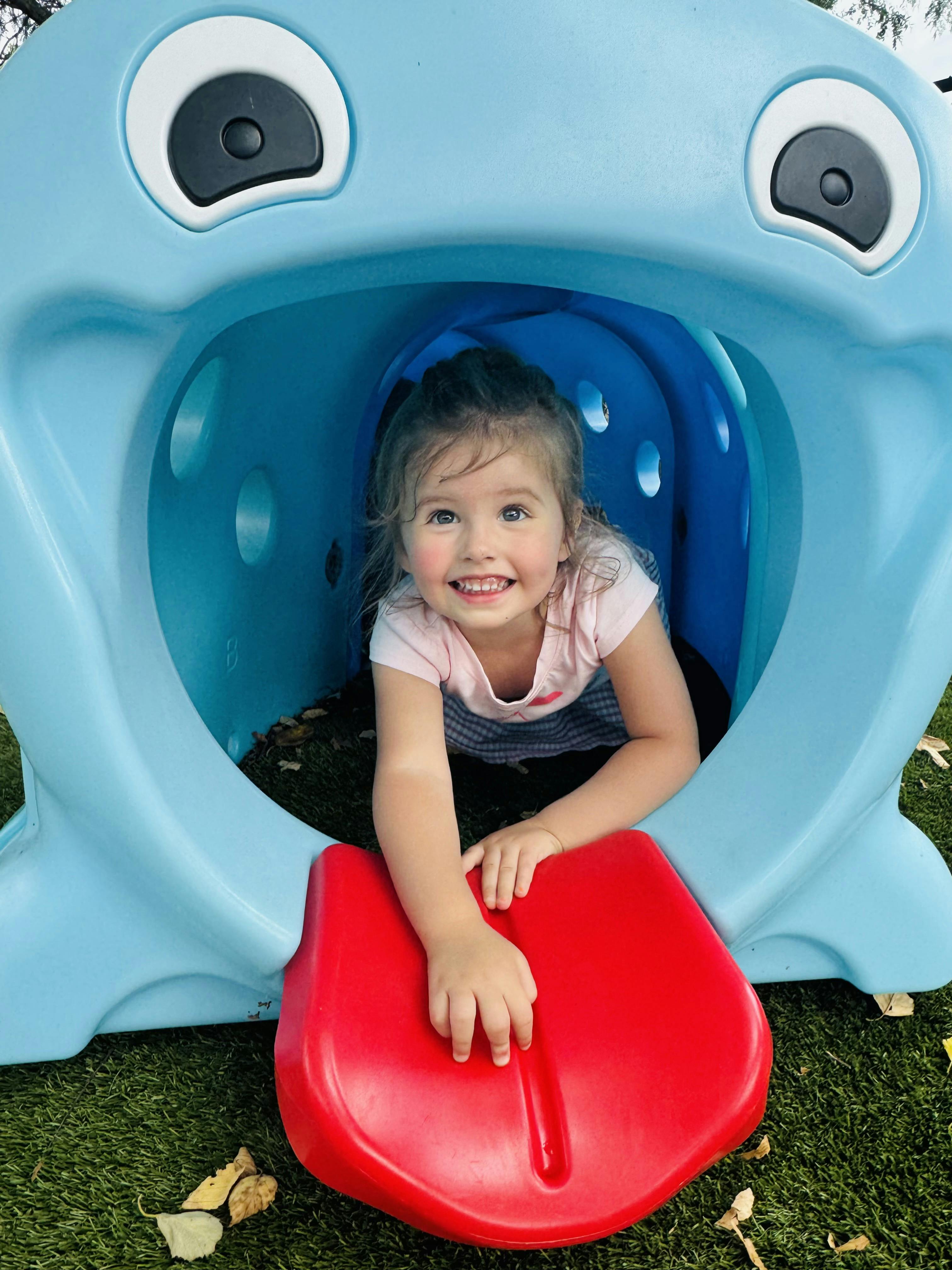 Child in a blue play tunnel