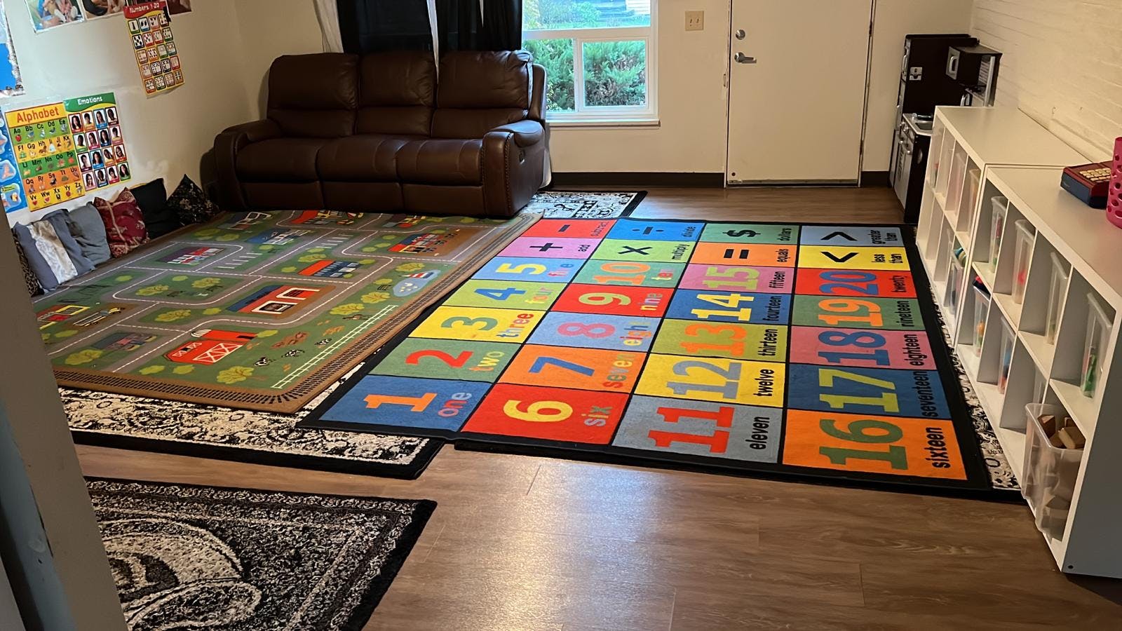 Playroom with two colorful rugs, one with numbers and one with a road map