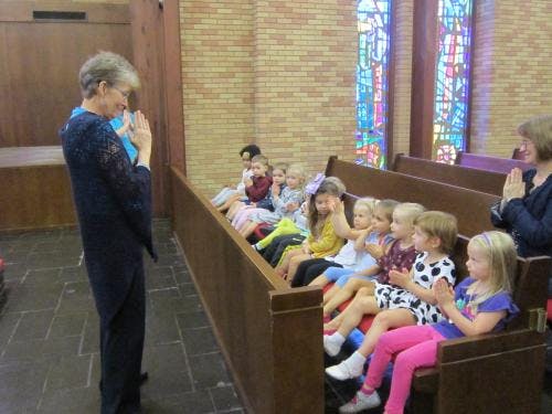 Adult and children sitting in pews