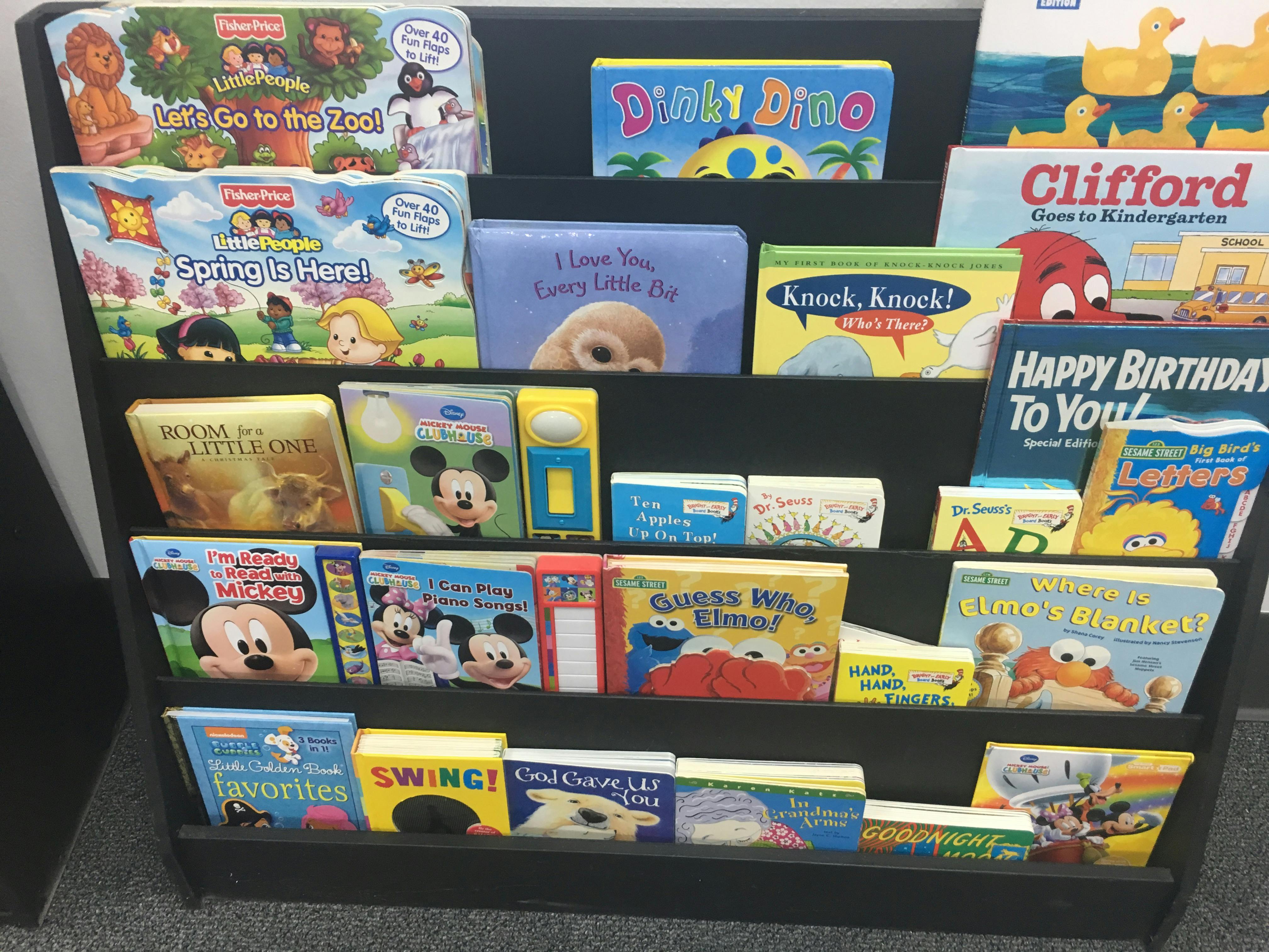 Children's books displayed on a black bookshelf