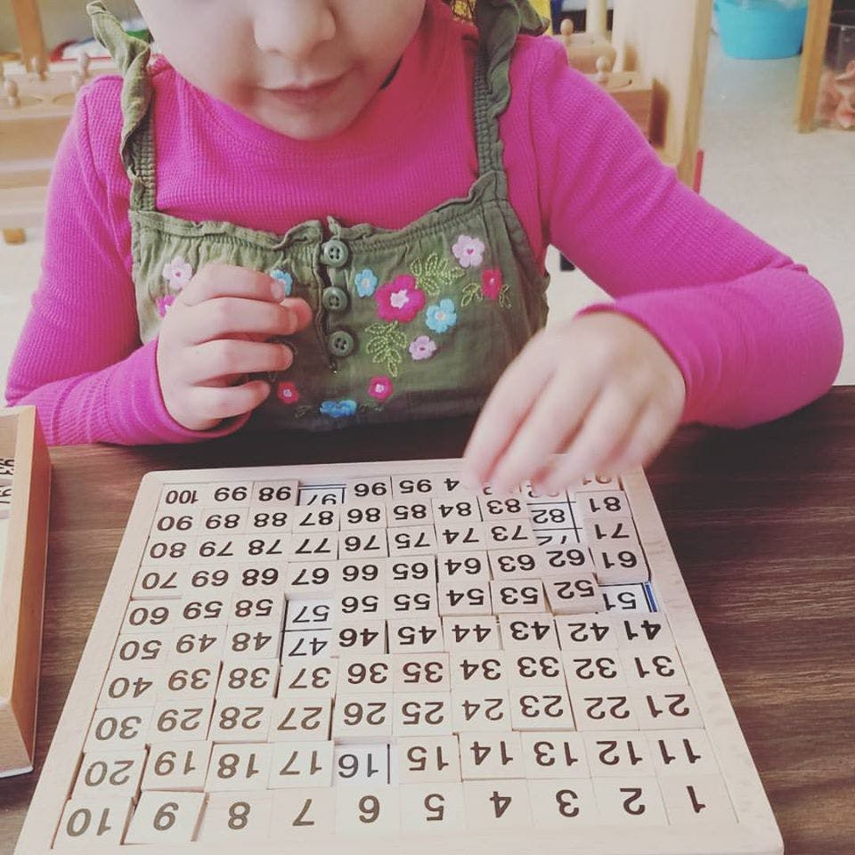Child playing with a wooden number board