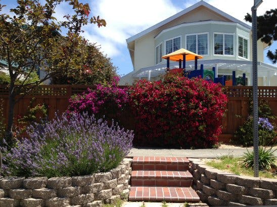 Brick steps leading up to a house with a playground in the yard