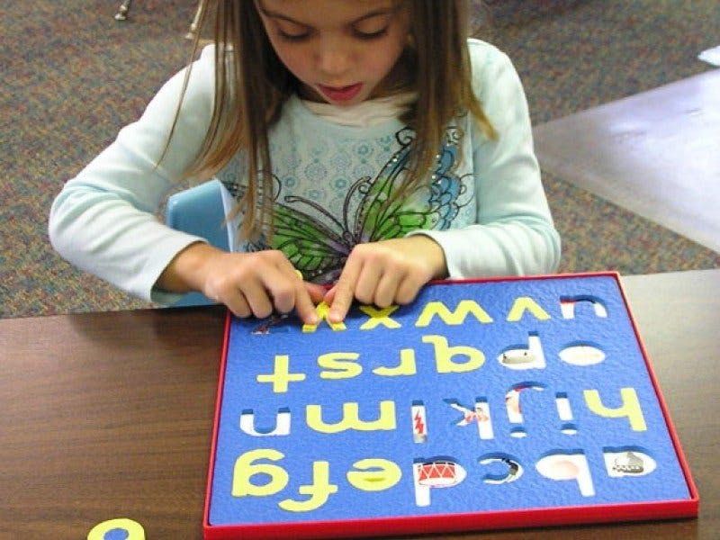 Child playing with an alphabet puzzle