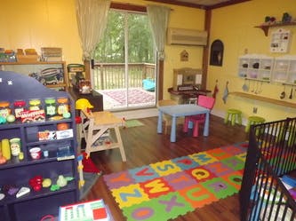 Playroom with toys, small table and chairs, and alphabet mat