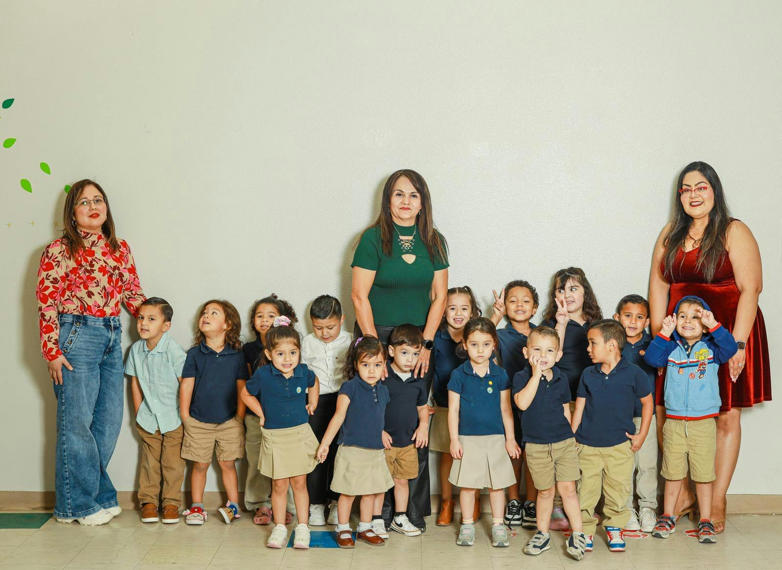 Three adults and a group of children standing together