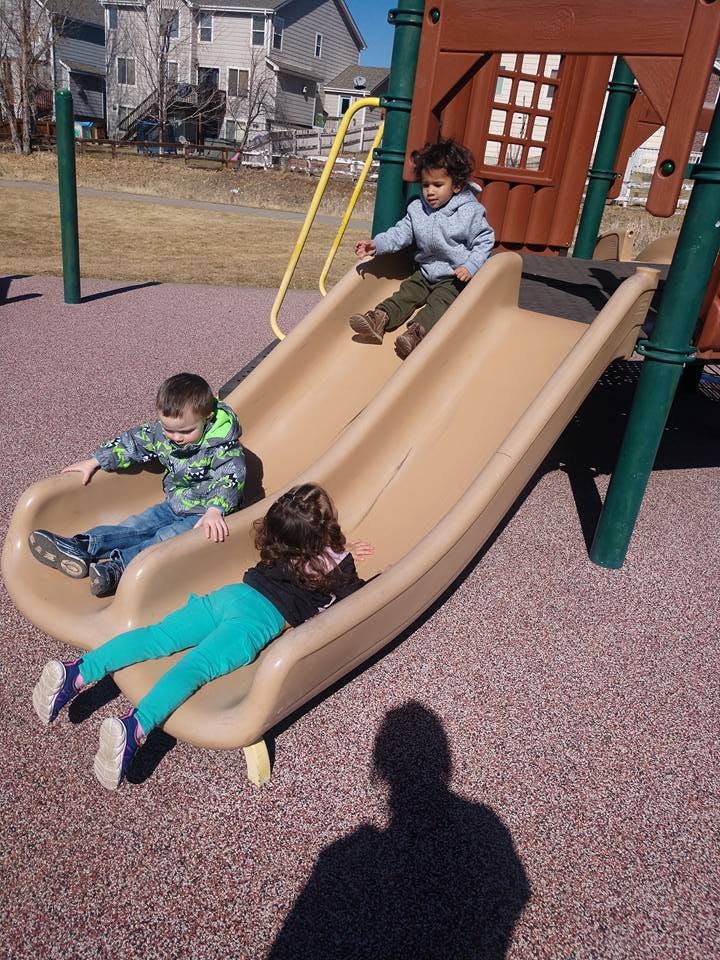 Three children on playground slides