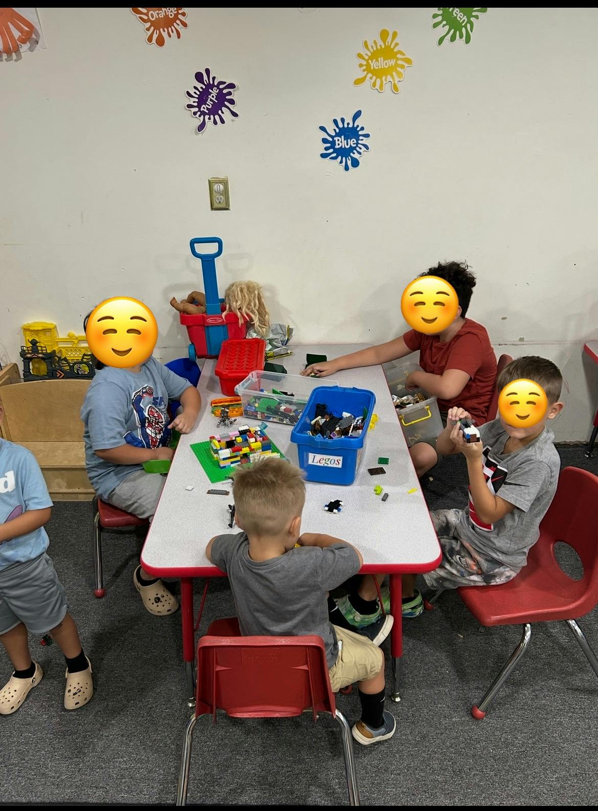 Children playing with building blocks at a table in a classroom