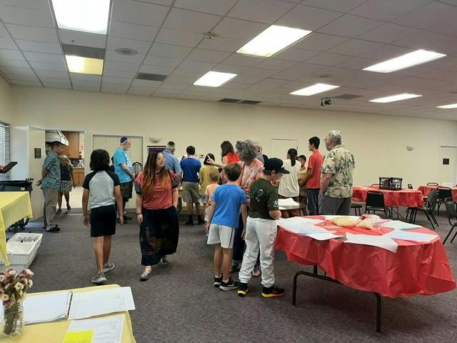 People gathered in a multipurpose room with tables