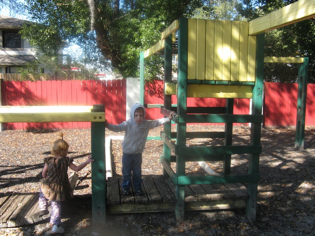 Two children on a wooden playground structure