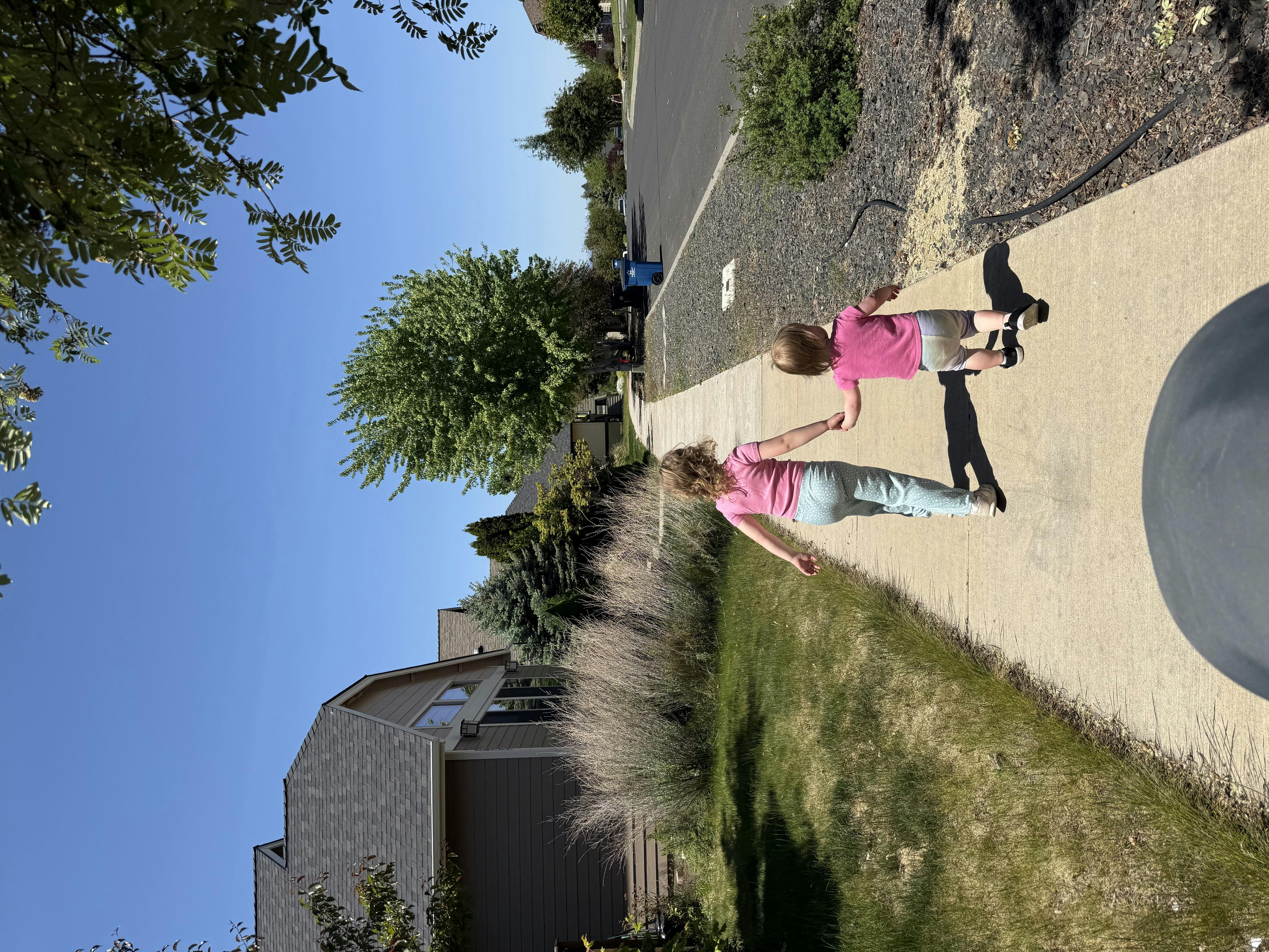 Person and child walking on a sidewalk