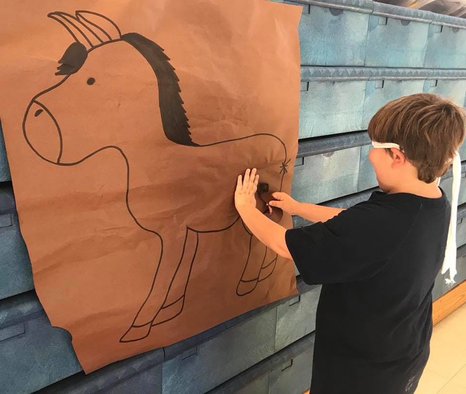 Child playing pin the tail on the donkey