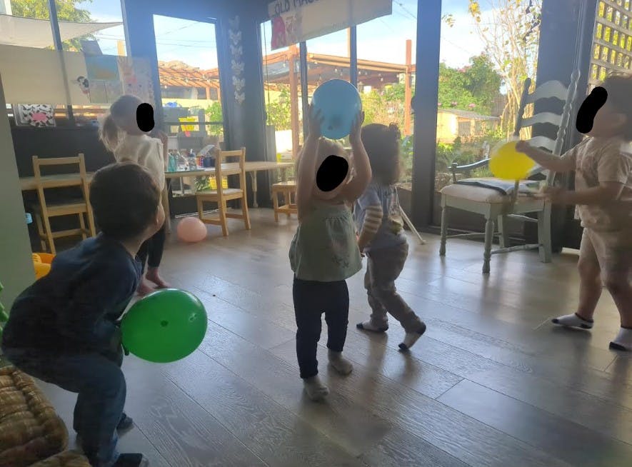 Children playing with balloons indoors