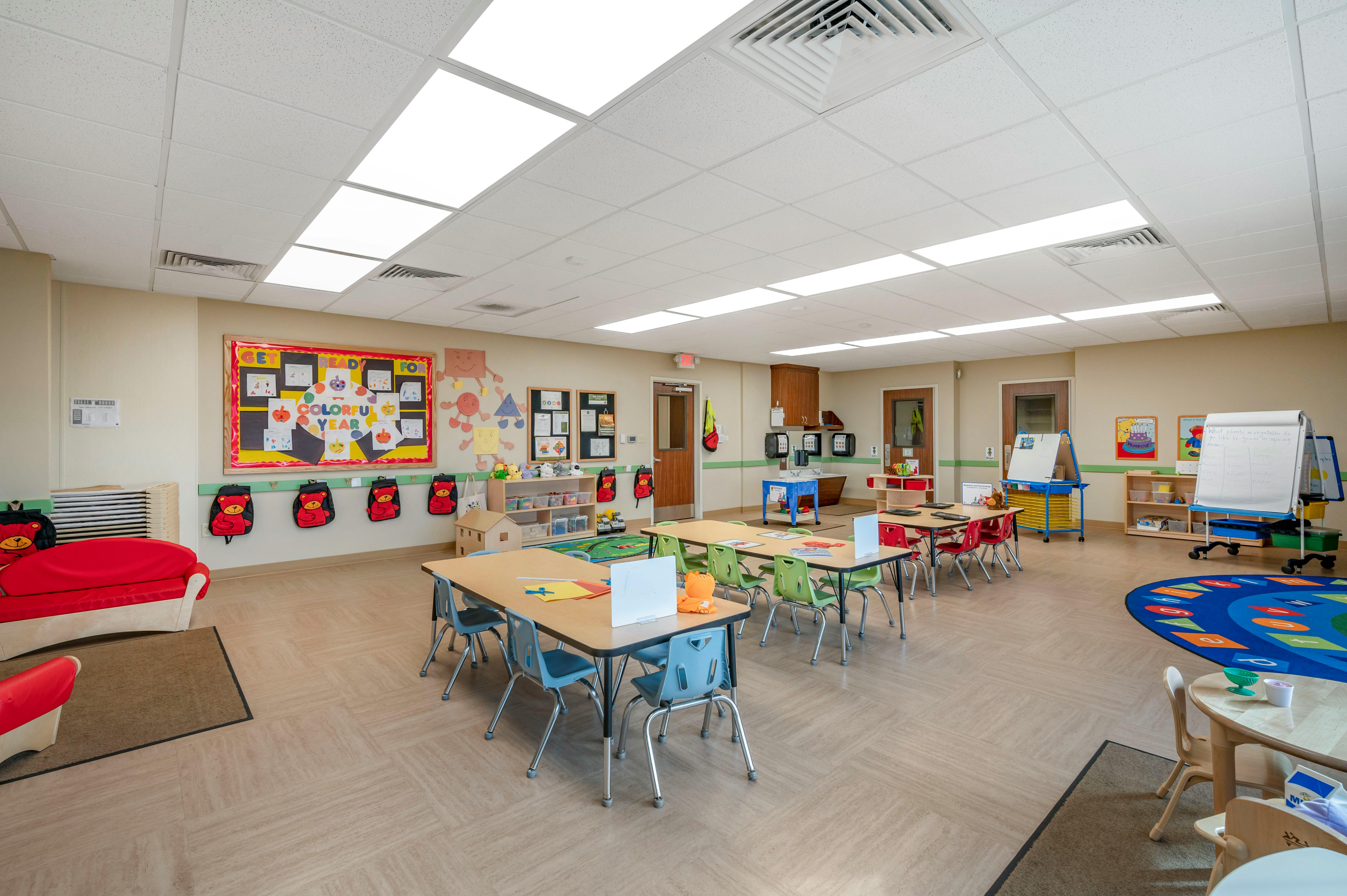 Classroom with tables, chairs, red couch, and colorful decorations