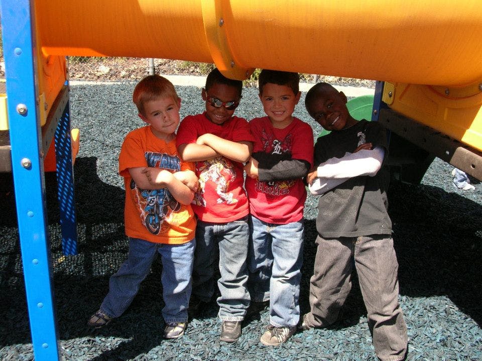Four children standing under playground equipment