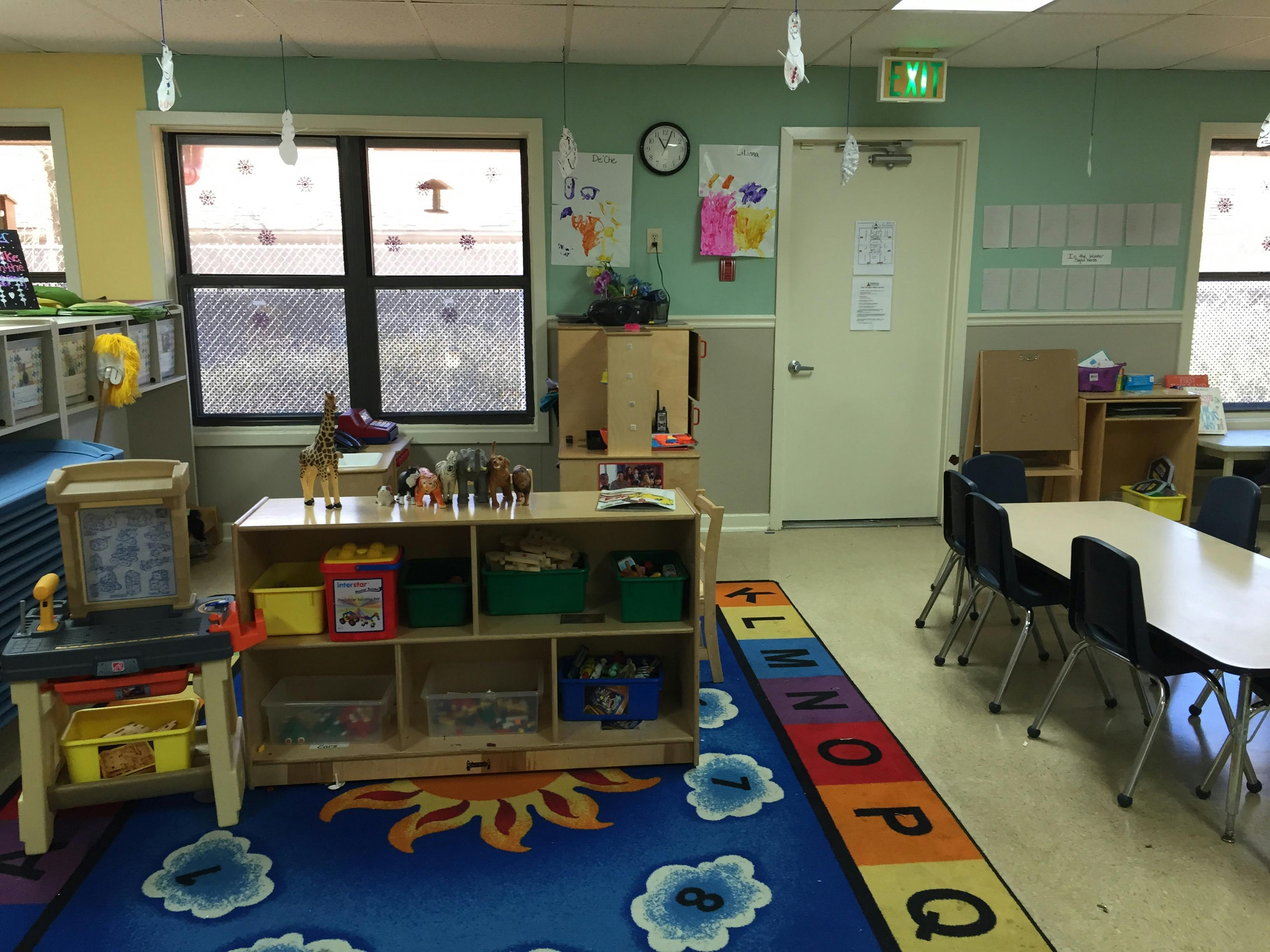 Classroom with child-sized furniture and a colorful alphabet rug