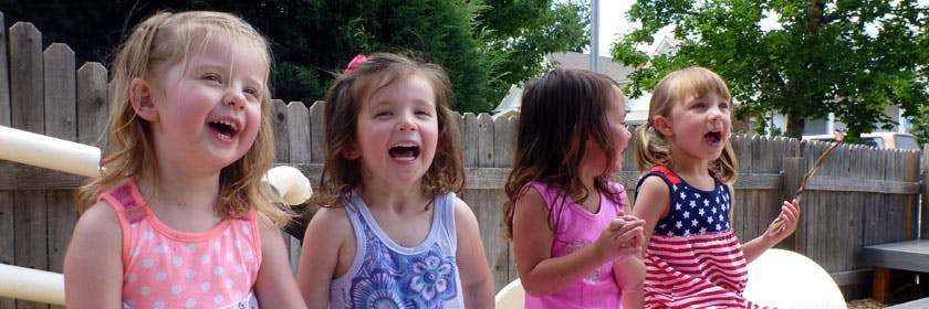 Four children laughing outdoors