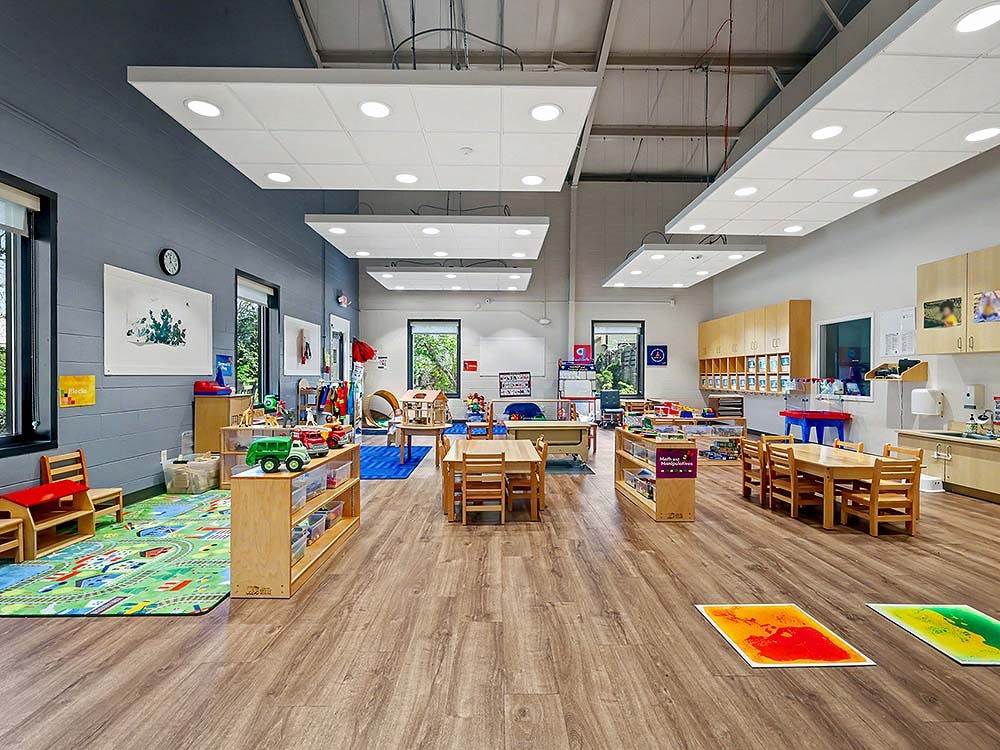 Classroom with child-sized furniture and colorful play mats on the floor