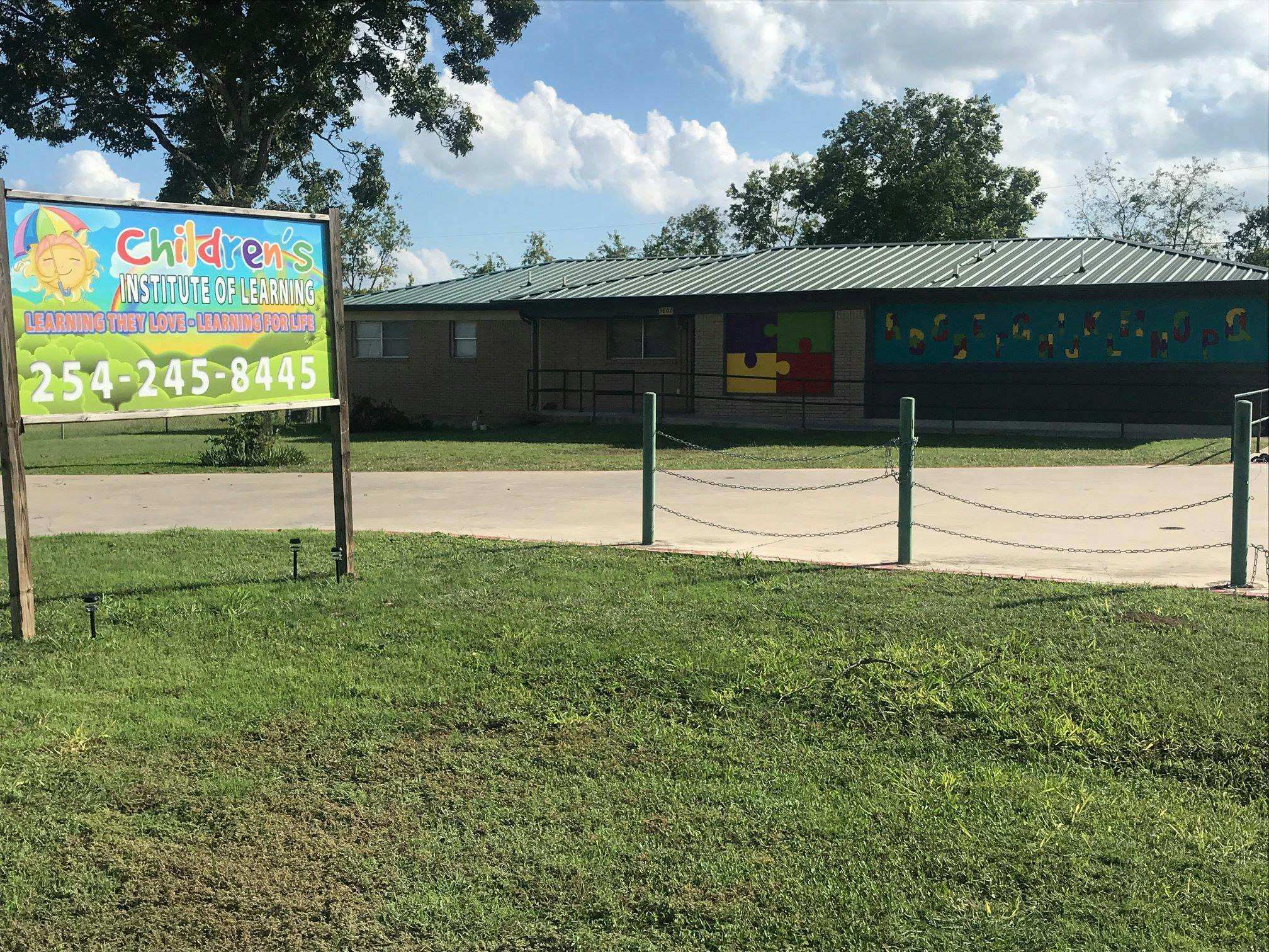 Sign for Children's Institute of Learning with a building in the background