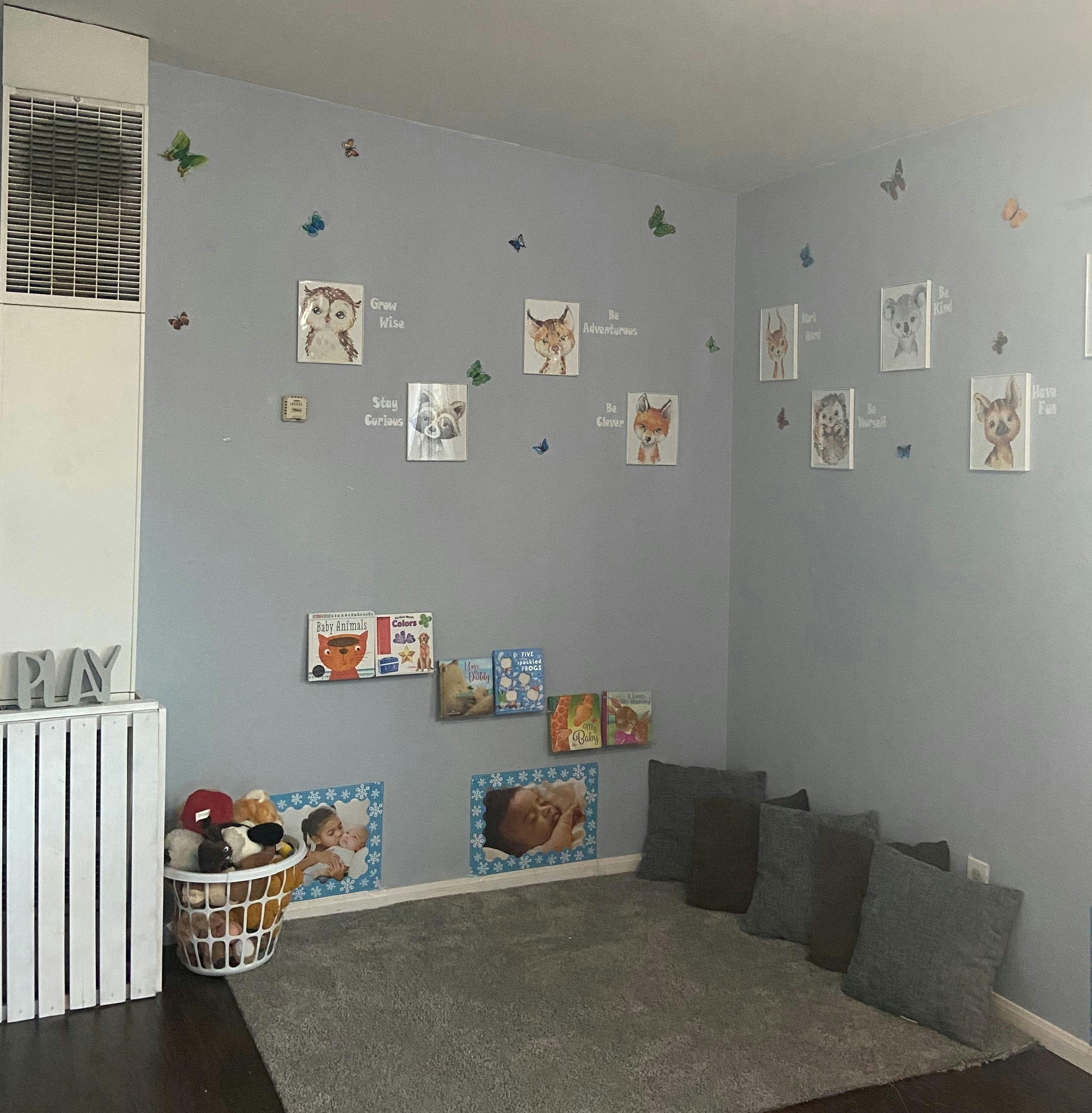 Room with wall decorations, books, and floor cushions