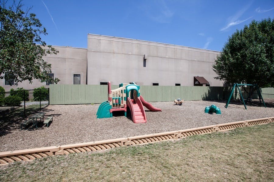 Playground with slides and swings in front of a building