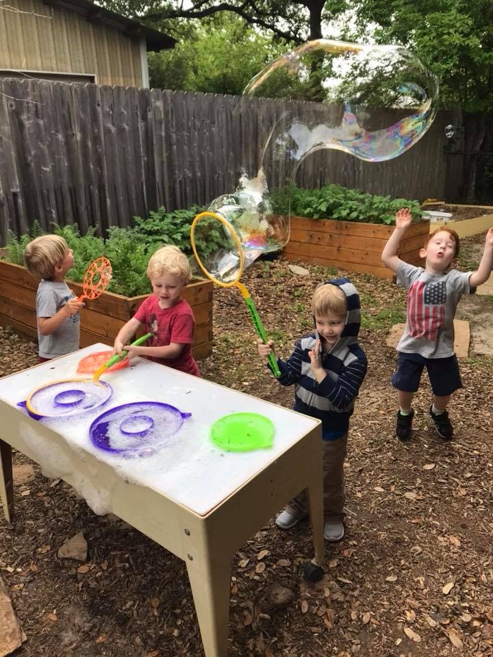 Children playing with bubbles outdoors