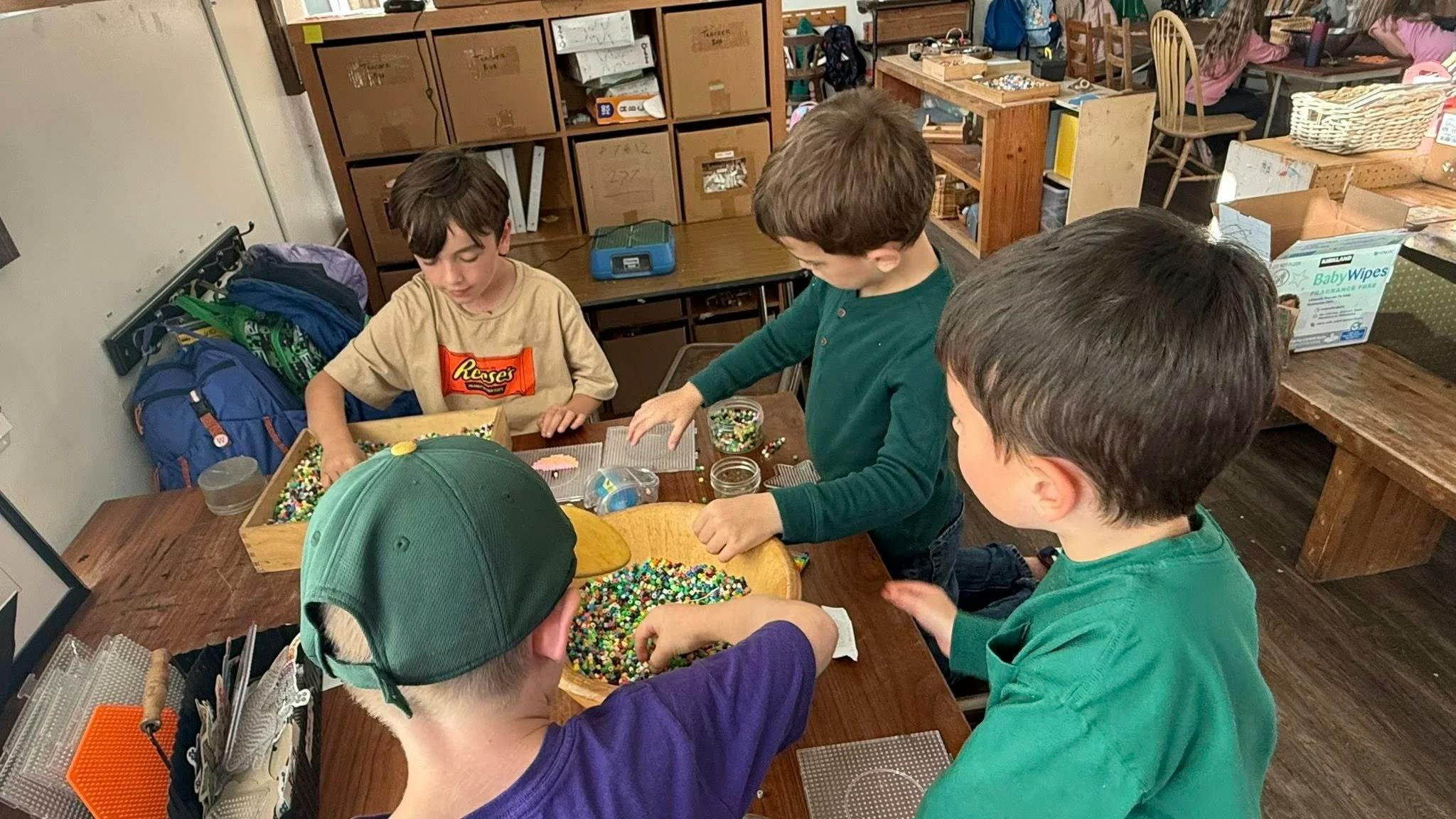 Children working with colorful beads at a table