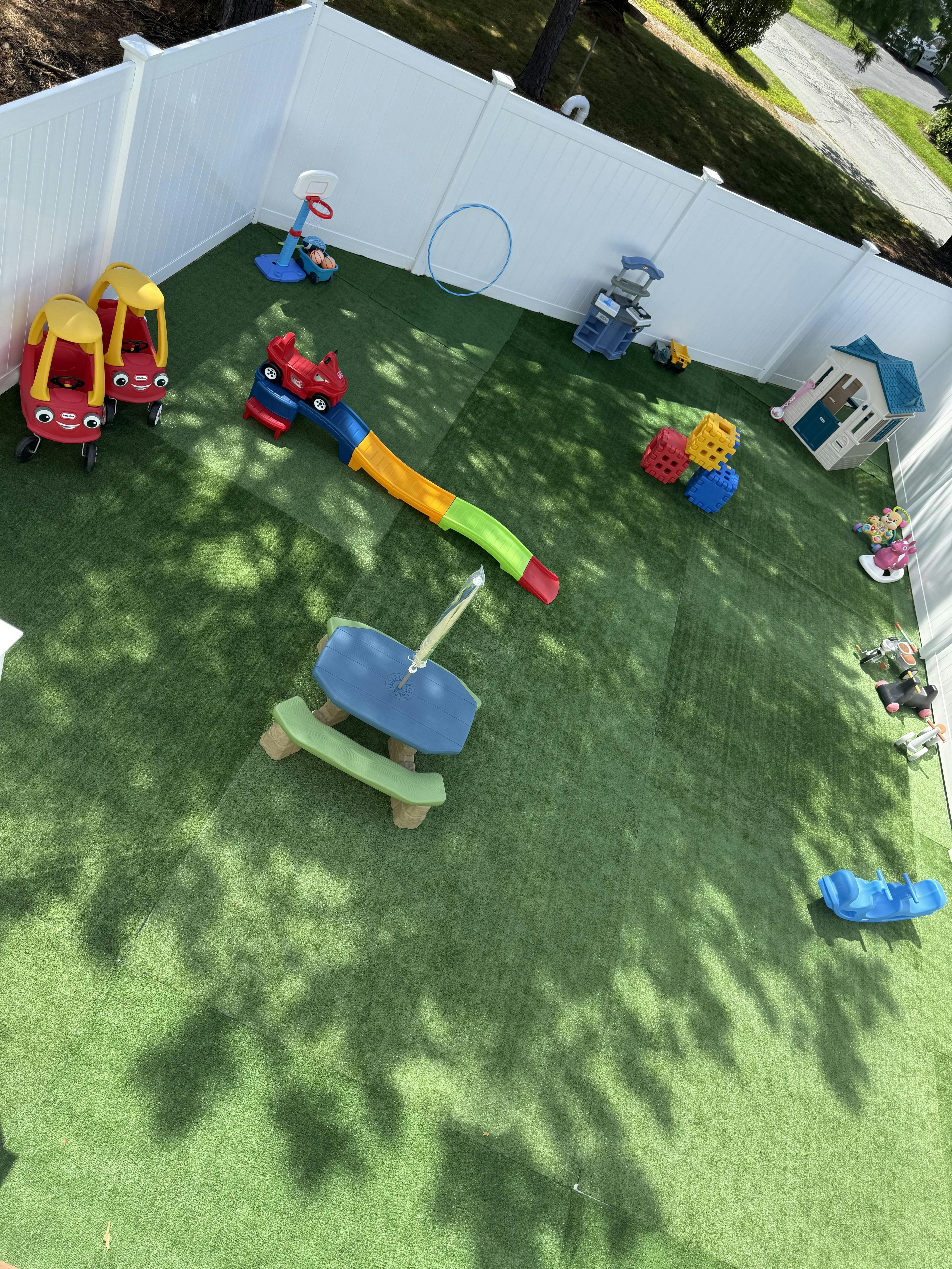 Plastic play equipment in a fenced backyard