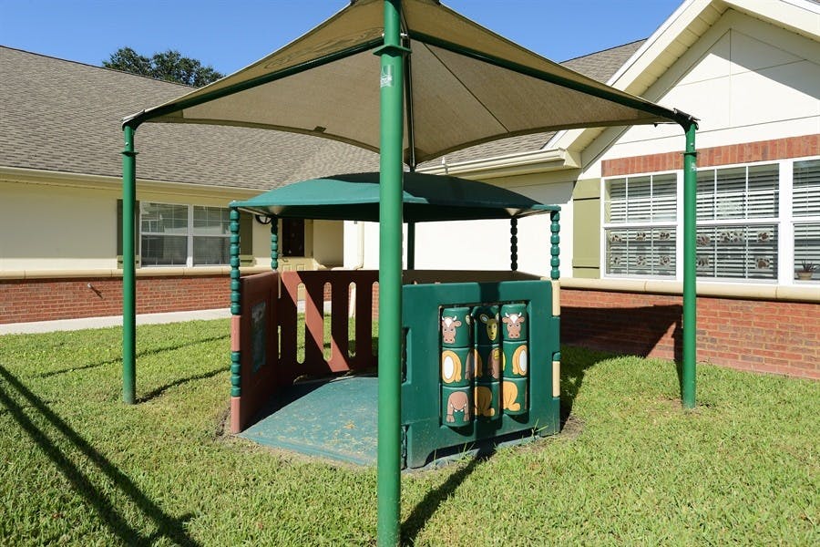 Playground structure with a green roof and a shade canopy