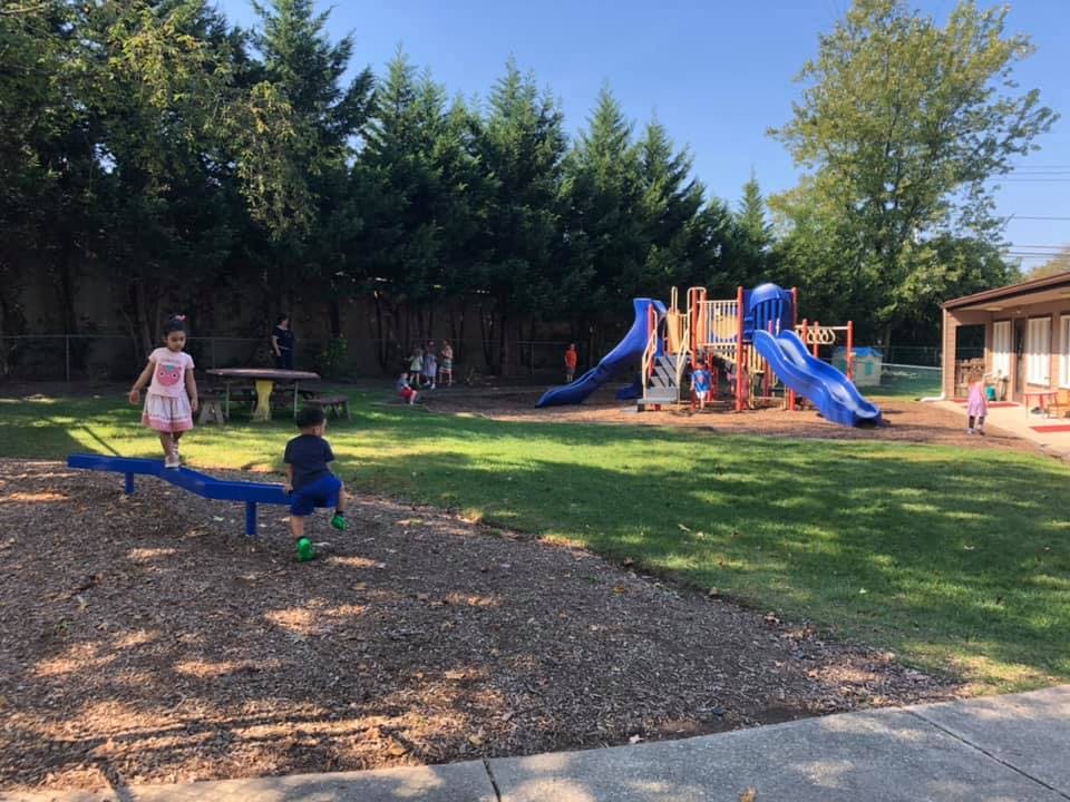 Children playing on a seesaw and playground equipment