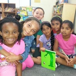 Group of children sitting on the floor with a book