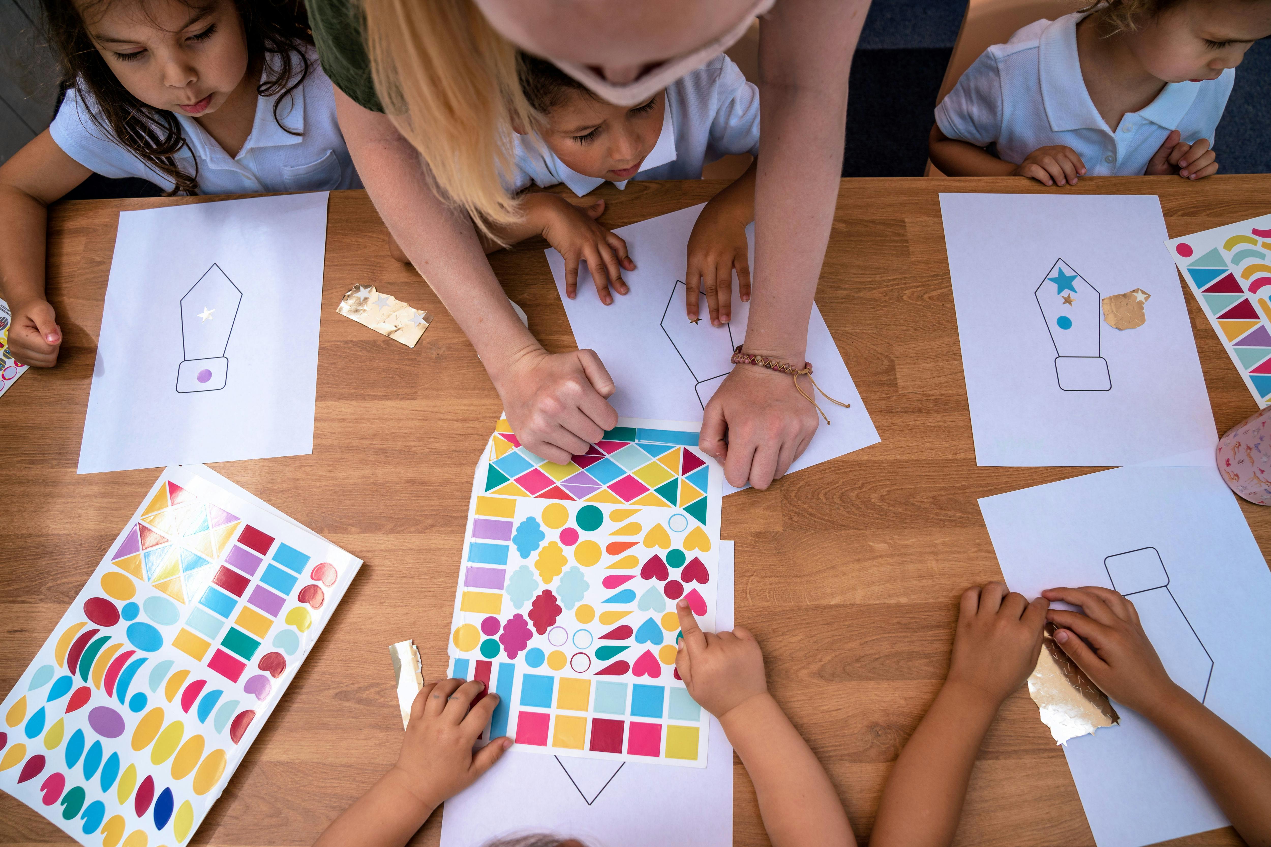 Adult and children decorating paper ties with colorful stickers
