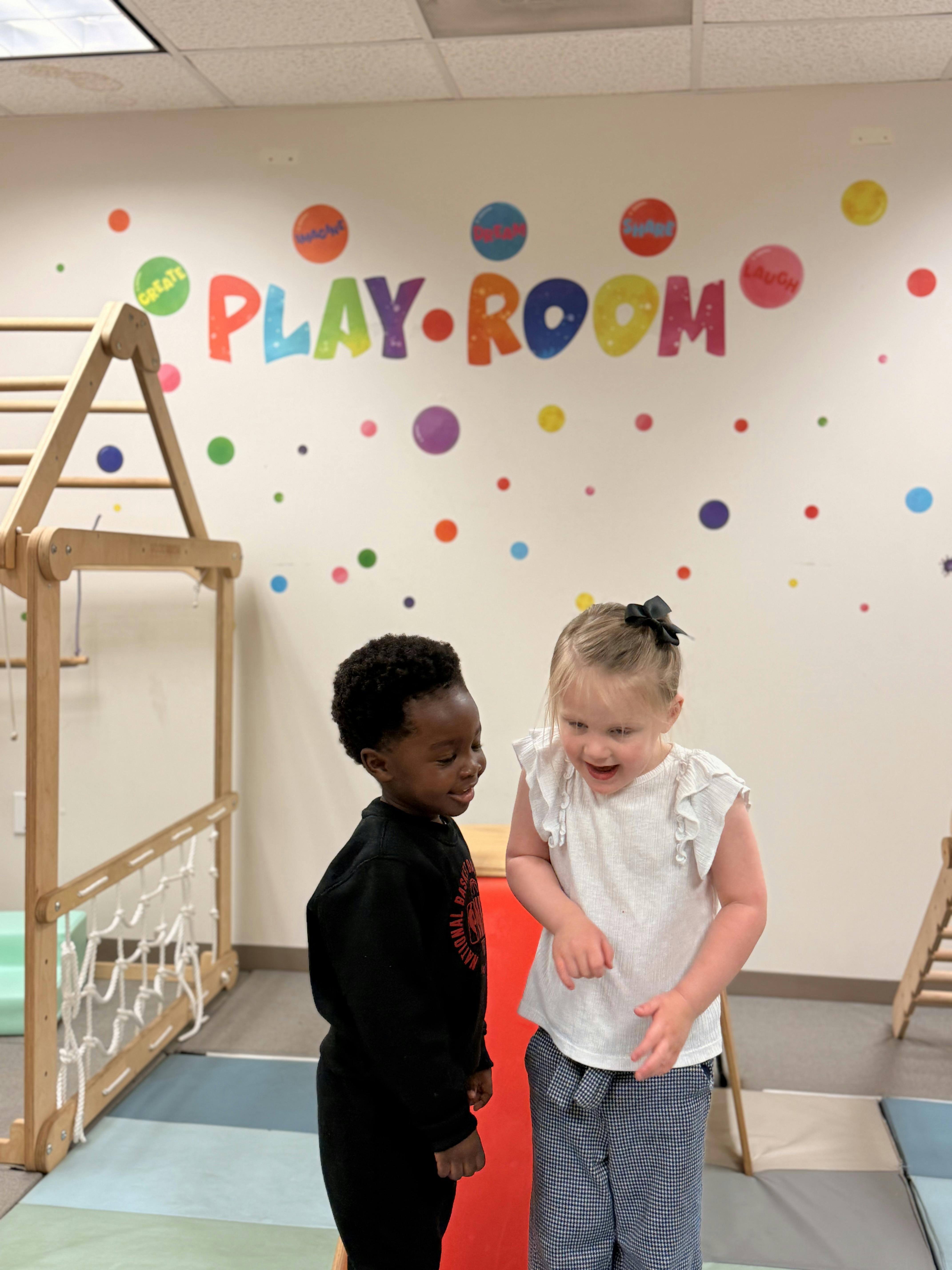 Two children playing in a room with a sign that says Play-Room