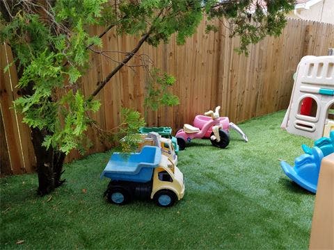 Toy dump truck and tricycle on artificial grass